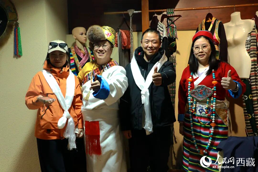 游客在扎西曲登社區(qū)體驗藏族服飾文化。大家身著色彩鮮艷的藏裝，佩戴特色飾品，臉上洋溢著喜悅的笑容。人民網(wǎng)記者 吳雨仁攝