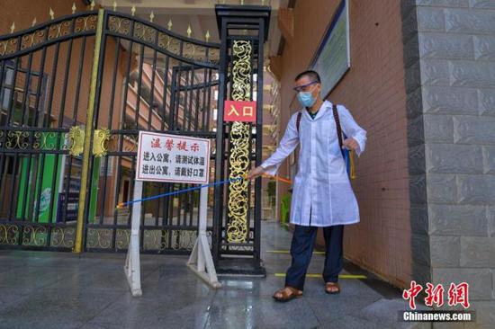 資料圖：?？诮?jīng)濟學院的工作人員在學生宿舍樓入口消毒。 中新社記者 駱云飛 攝