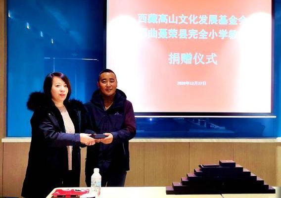 圖為西藏高山文化發(fā)展基金會(huì)理事長(zhǎng)溫麗向聶榮縣完全小學(xué)負(fù)責(zé)人捐助儀器?！∮谫e 攝