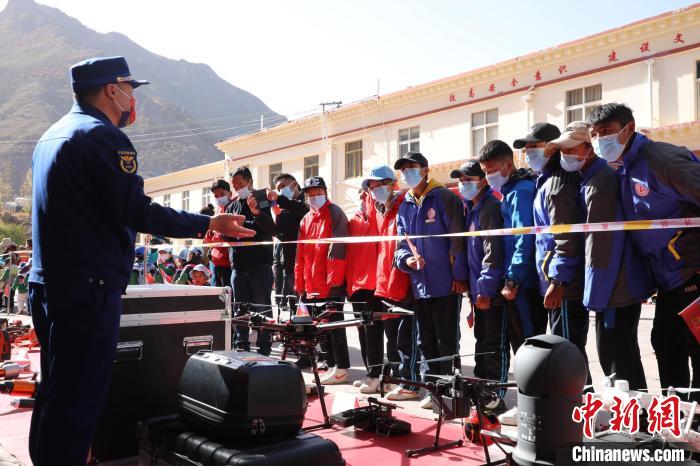 圖為消防指戰(zhàn)員為學(xué)生講解、演示先進救援裝備。　趙琳 攝