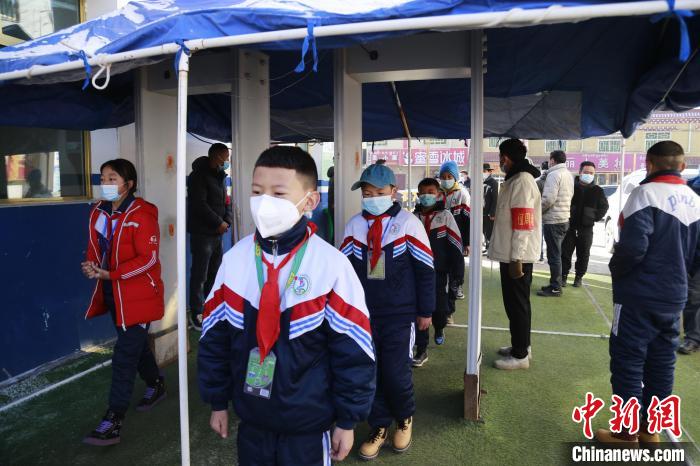 圖為學(xué)生測(cè)量體溫后進(jìn)入校園?！●R銘言 攝