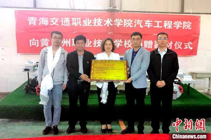 圖為李富香(中)代表學(xué)校為州縣技校捐贈(zèng)器材。(資料圖) 青海省教育廳供圖