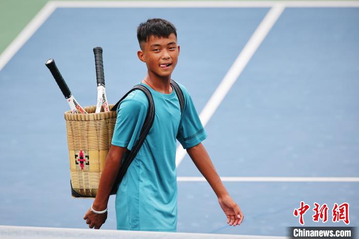 王發(fā)背著背簍在賽場上。　李建藝 攝