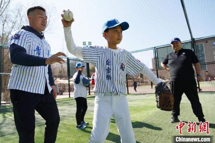 圖為教練指導(dǎo)小棒球手?jǐn)S球技術(shù)?！●R銘言 攝