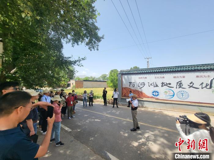 圖為中國地質(zhì)大學(xué)(北京)教授張緒教介紹村落情況。　胡友軍 攝