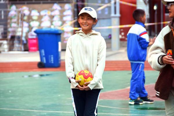 在高原上教孩子們打手球，“慢慢兒來，甭著急！”