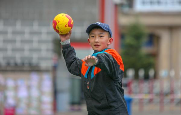 在高原上教孩子們打手球，“慢慢兒來，甭著急！”