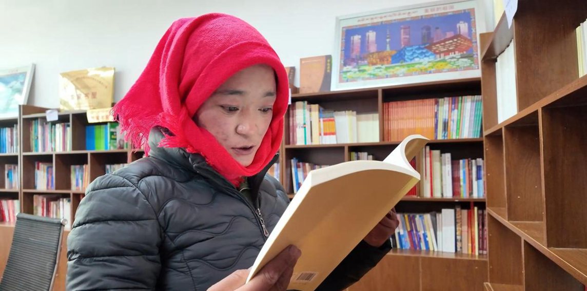 一名婦女正在認(rèn)真閱讀書(shū)籍。申扎縣融媒體中心供圖