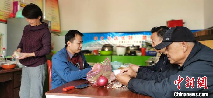 圖為扶貧路上“臨時(shí)一家人”準(zhǔn)備午餐。　魏建軍 攝