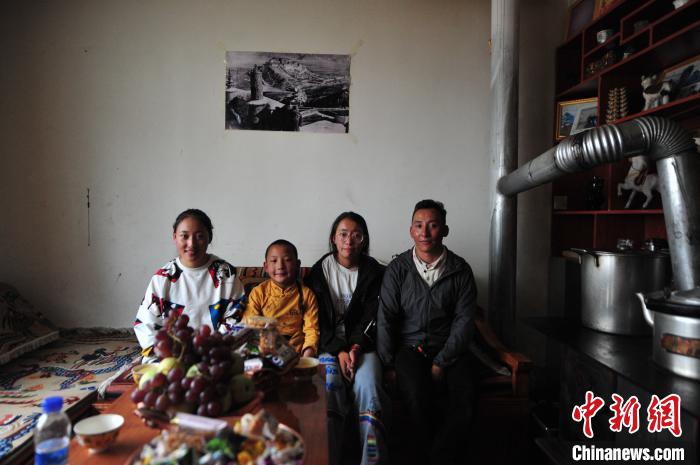 圖為8月12日，2018年7月從距那曲市色尼區(qū)城區(qū)那曲鎮(zhèn)90千米外的古露鎮(zhèn)當桑村搬遷至城區(qū)的旦增(右一)與家人在80多平方米的新家合影(資料圖)?！垈?攝
