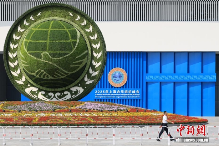 8月31日，天津，一名工作人員從2025年上海合作組織峰會主會場外的景觀花壇旁經過。當日，2025年上海合作組織峰會在天津舉行。<a target='_blank' href='/'><p  align=