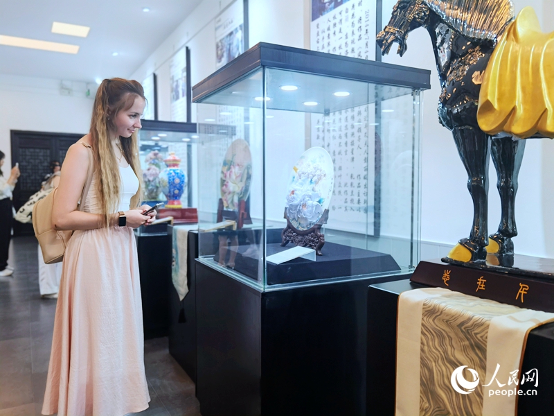 來自白俄羅斯的留學(xué)生喀秋莎駐足欣賞牡丹瓷。人民網(wǎng)記者 尚明楨攝