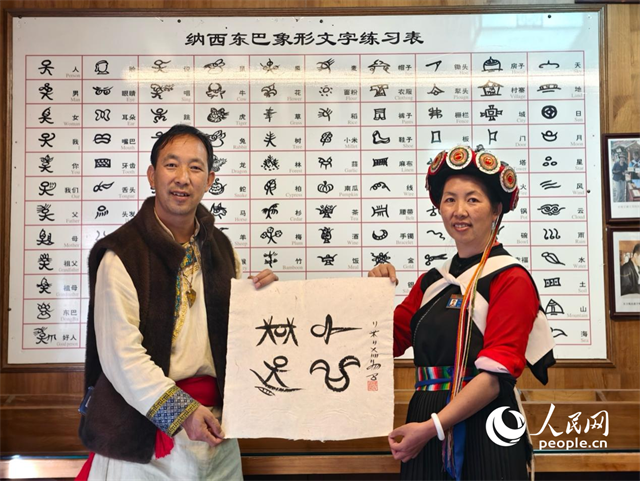 人民網(wǎng)“行進中國”云南調(diào)研采訪團走進麗江，和閏元現(xiàn)場用東巴文寫下“行進中國”。人民網(wǎng)記者 符皓攝