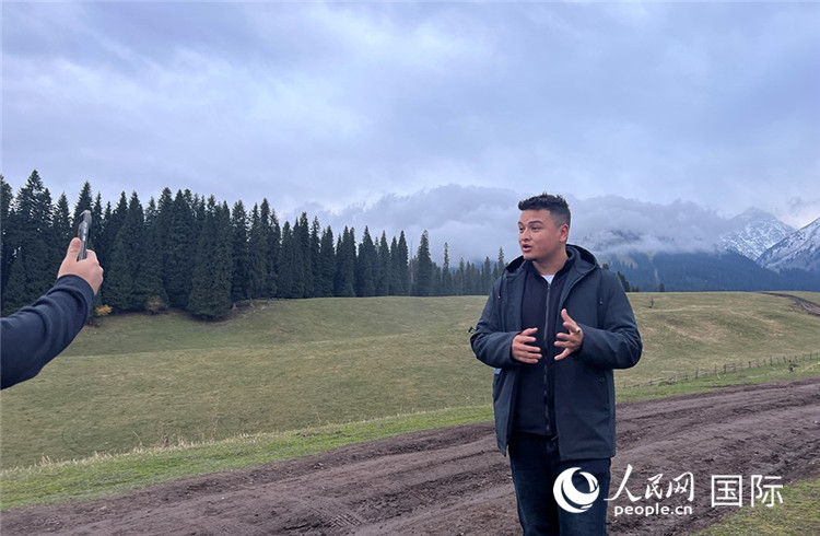 在庫爾德寧，吾買爾江被雪山美景震撼，即興錄制了短視頻作品。人民網(wǎng)記者曾書柔攝