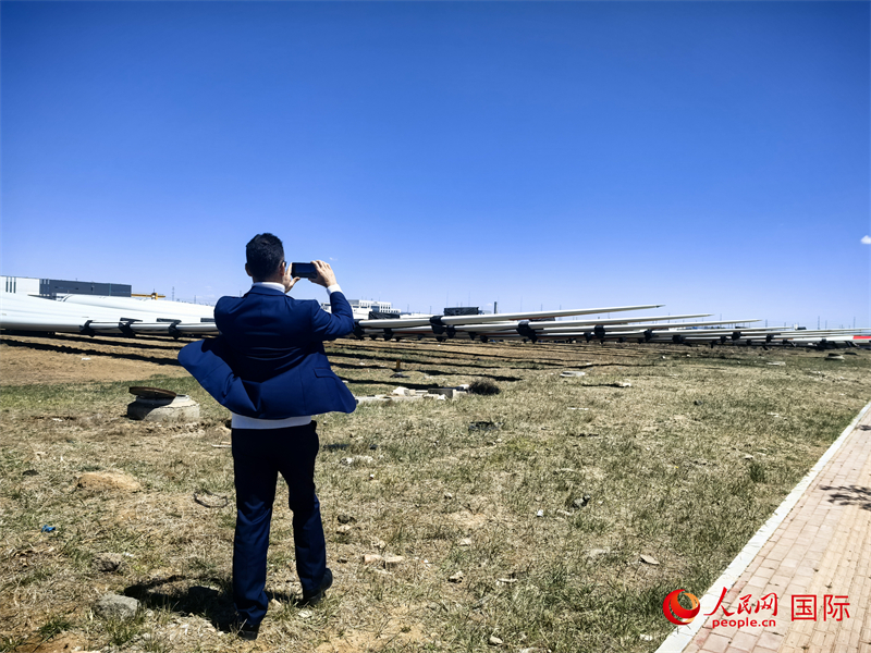 外媒記者拍攝廠房外的風(fēng)力渦輪發(fā)電機(jī)的巨型漿葉。人民網(wǎng) 楊春燕攝