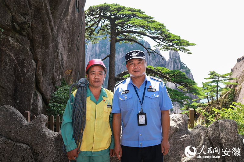 全國道德模范李培生（左）和胡曉春在迎客松前合影。人民網(wǎng)記者 張俊攝