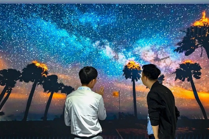 長(zhǎng)春光博會(huì)希達(dá)電子展區(qū)，一位工作人員正在給一位觀眾講解。（長(zhǎng)春新區(qū)供圖）