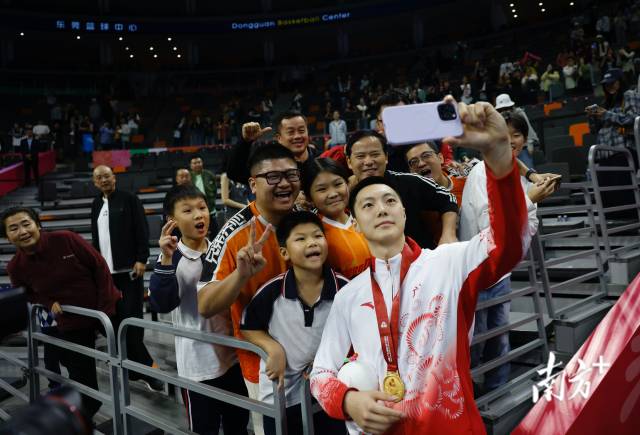 11月12日，十五運會男籃成年組決賽，廣東隊獲得冠軍后，胡明軒與球迷們合影留念。張由瓊 攝