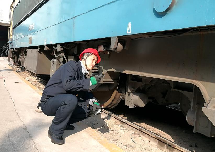 韓文盛全神貫注檢查機(jī)車走行部。