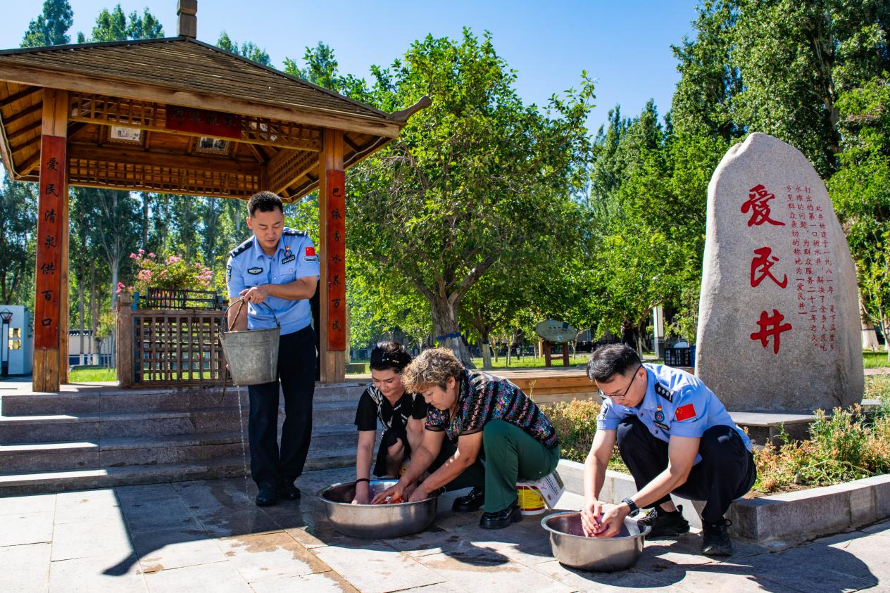下馬崖邊境派出所民警與轄區(qū)群眾在“愛(ài)民井”旁，一同打水洗菜、架鍋?zhàn)鲲垺Ｏ埋R崖邊境派出所供圖