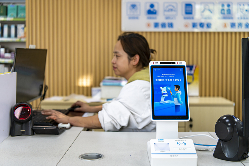 2024年4月10日，浙江金華市區(qū)一家民眾大藥房柜臺上設(shè)置著醫(yī)?！八⒛樦Ц丁睓C(jī)器，群眾看病更加便利。