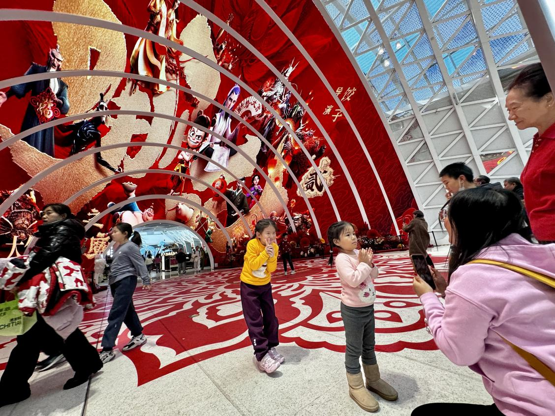 乙巳蛇年春節(jié)期間，影迷在《哪吒之魔童鬧?！肪薹?bào)前拍照打卡。