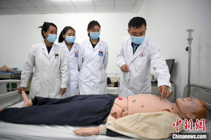 湖南中醫(yī)藥大學(xué)第一附屬醫(yī)院腦病科援藏醫(yī)生高曉峰(右一)為學(xué)生們進行體格檢查教學(xué)。　楊華峰 攝