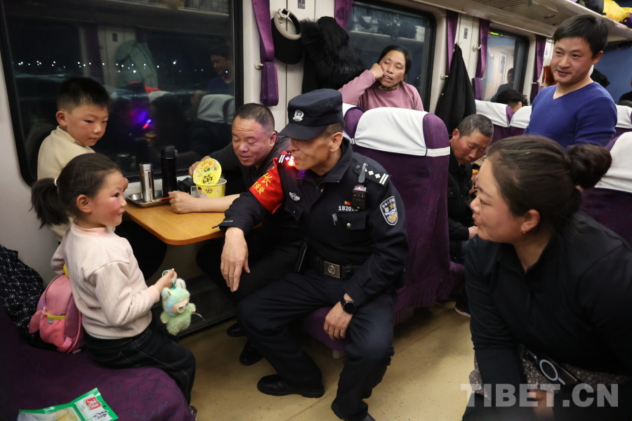乘警長(zhǎng)左紅彬在巡視車廂間隙，向攜帶兒童的旅客專門叮囑安全注意事項(xiàng)。.JPG