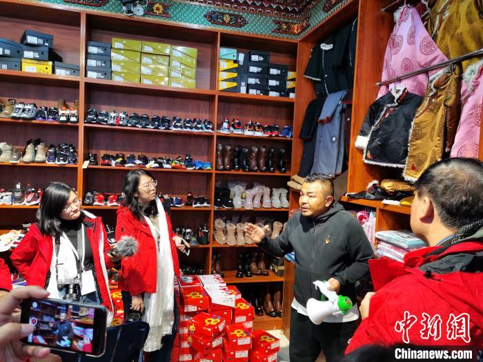 圖為中外媒體在玉樹州玉樹市甘達(dá)村采訪?！?zhí)砀?攝