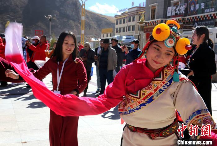 圖為中外記者向當(dāng)?shù)孛癖妼W(xué)習(xí)民族歌舞文化。　張?zhí)砀?攝