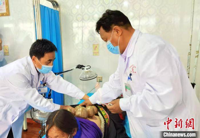 圖為看照加手把手帶徒弟加老(左一)進行拔罐療法?！堟?攝