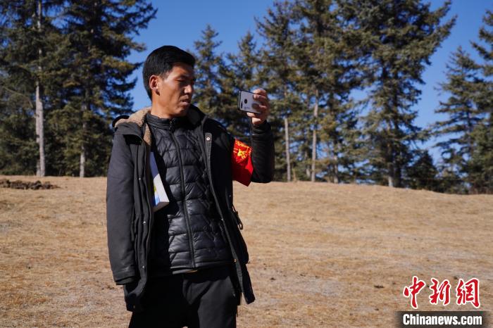 圖為桑杰加進(jìn)行巡查并拍照記錄?！●R銘言 攝