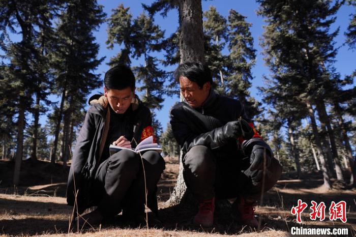 圖為桑杰加(左)和同事記錄巡查結(jié)果?！●R銘言 攝