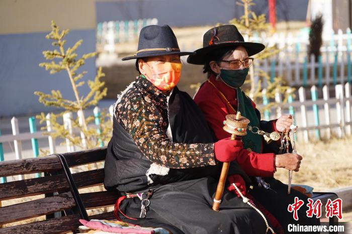 圖為敬老院老人在院內曬太陽轉經桶?！●R銘言 攝