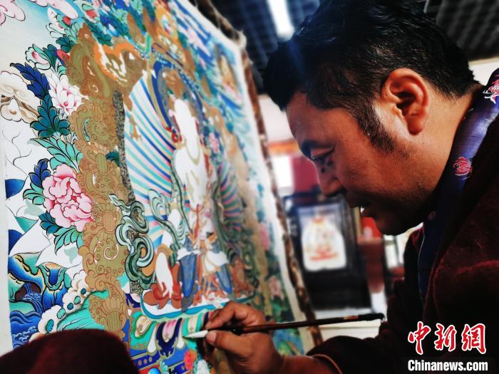 圖為久美尖措創(chuàng)作唐卡?！?zhí)砀?攝