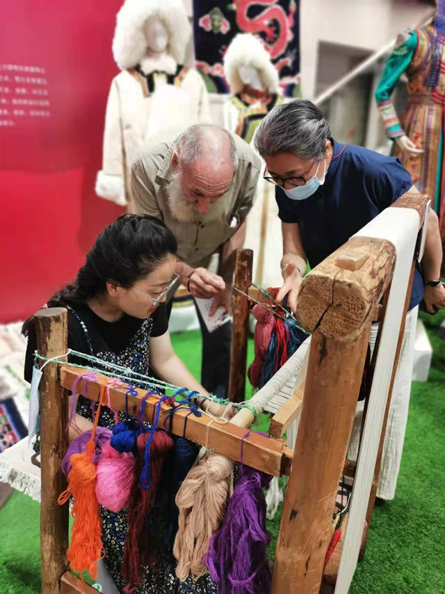 楊永良的學(xué)生在展會上向客商介紹加牙藏毯編織技藝。受訪者供圖