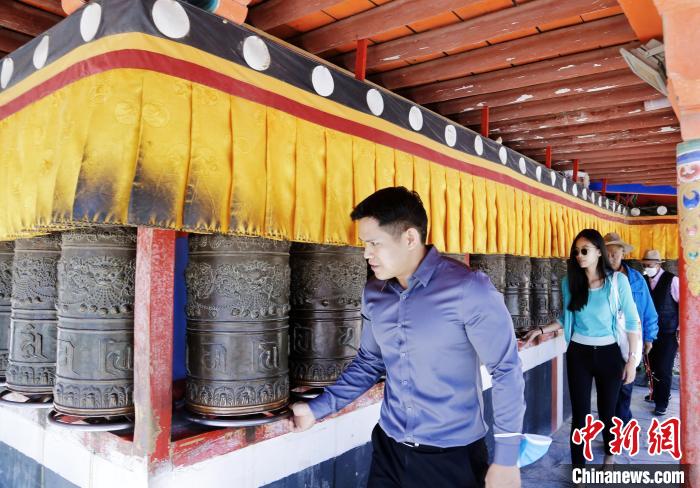 圖為外籍嘉賓體驗藏族傳統(tǒng)轉經筒?！●R銘言 攝