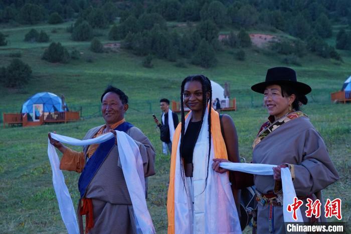 圖為當?shù)孛癖娕c外籍留學生合影留念。　馬銘言 攝