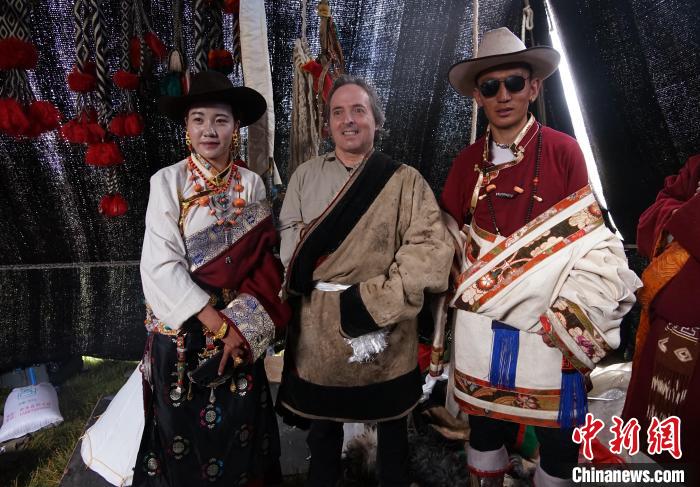 圖為一名外籍?dāng)z影師(中)身穿藏服和藏族民眾合影留念?！●R銘言 攝