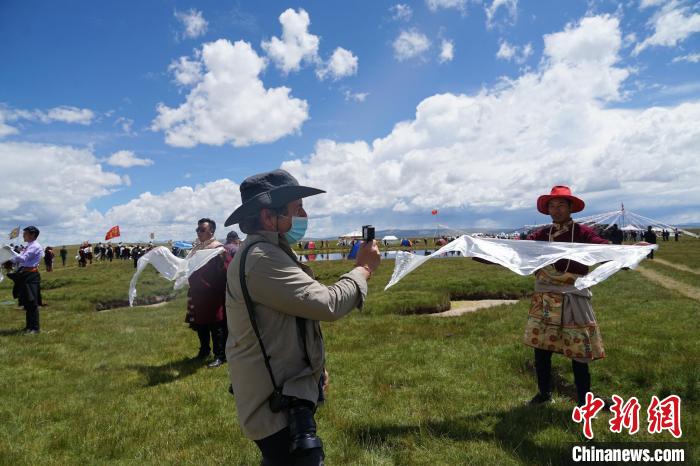 圖為一名外籍?dāng)z影師記錄當(dāng)?shù)夭刈鍤g迎儀式?！●R銘言 攝