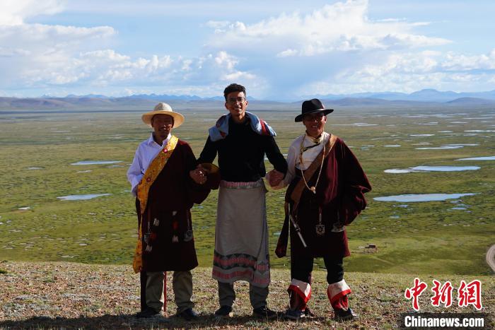 圖為一名留學(xué)生身穿自己國家的服飾和藏族民眾合影留念?！●R銘言 攝