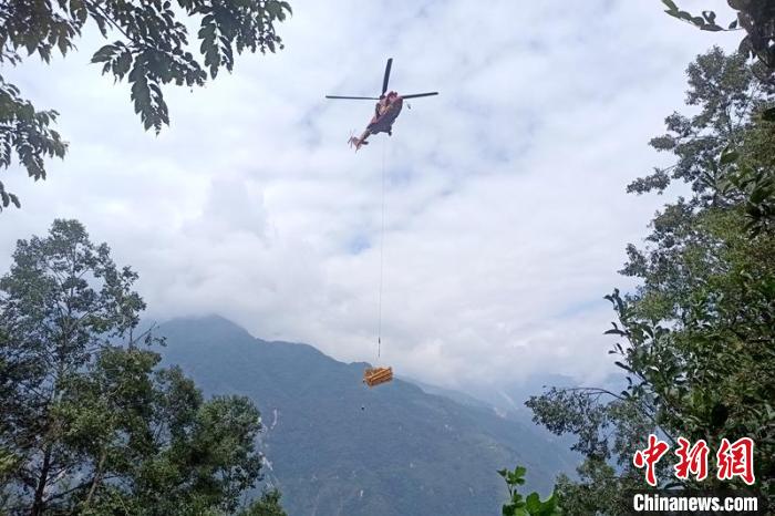 直升機起飛將搶修塔材運往海拔1950米的110千伏唐下線29號塔位?！⌒鞈c明 攝