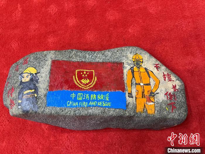 圖為玉樹消防指戰(zhàn)員創(chuàng)作的石頭畫作品《我有一個(gè)特點(diǎn)“不擅長(zhǎng)倒下”》?！O瑞祥 攝
