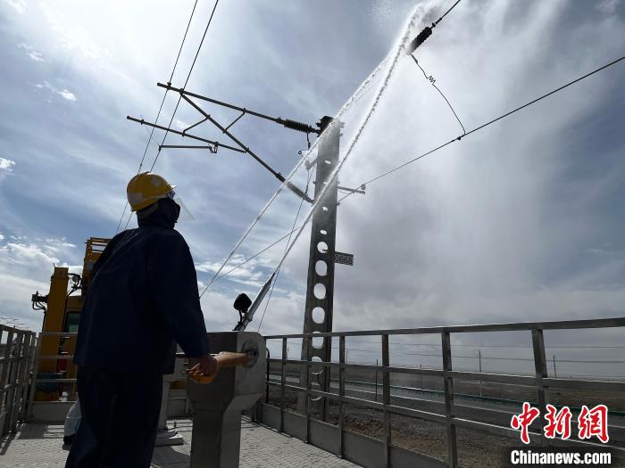 圖為高壓水槍的水柱沖洗絕緣子串。　高啟宏 攝