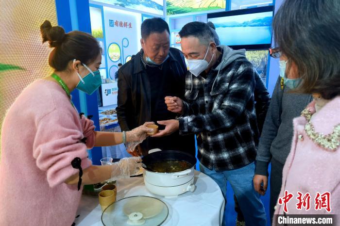 圖為杭州市民品嘗茶卡羊肉?！±铍h 攝