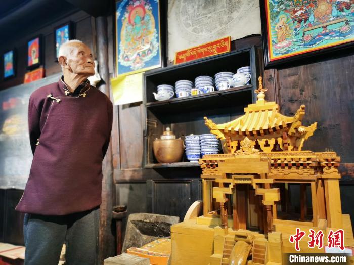 圖為古堡內(nèi)的藝人桑杰展示自己的雕刻作品。　張?zhí)砀?攝