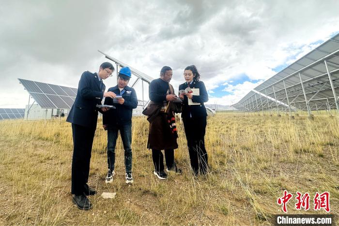 圖為稅務(wù)干部上門開展稅費(fèi)輔導(dǎo)?！》劫F龍 攝