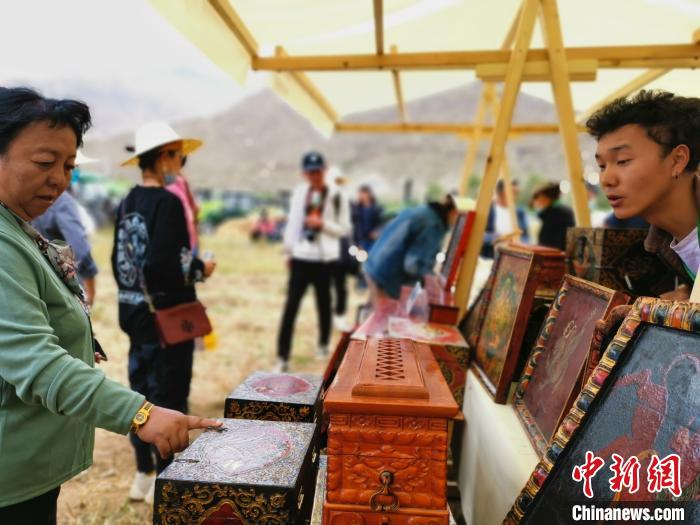 圖為拉薩市民在特色農(nóng)畜產(chǎn)品展示展銷會上選購商品?！垈?攝