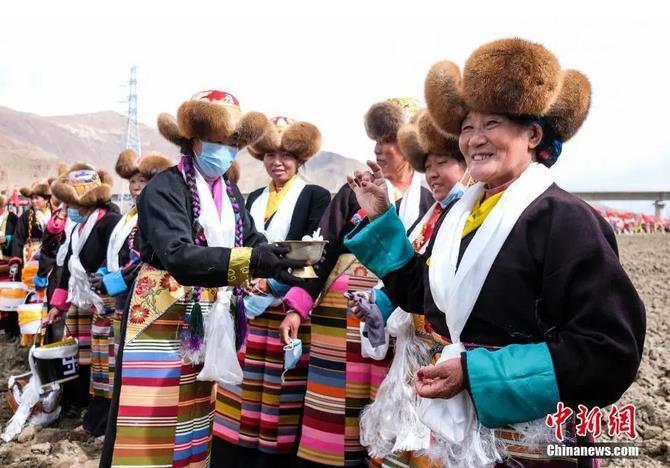 資料圖：西藏自治區(qū)拉薩市曲水縣才納鄉(xiāng)協(xié)榮村參加春耕儀式的村民互敬青稞酒。按照傳統(tǒng)，當(dāng)?shù)卮迕裆碇?jié)日盛裝，舉行隆重的儀式，祈福一年的豐收。<a target='_blank' ><p  align=