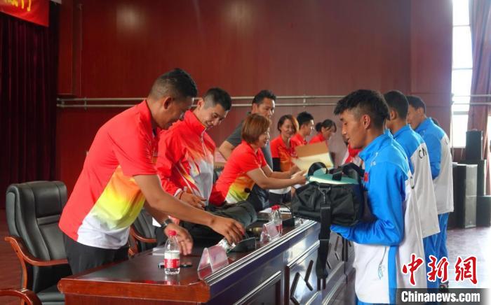 圖為世界冠軍們?yōu)槲鞑刈灾螀^(qū)體校的學(xué)生們送上暖心物資。　冉文娟 攝